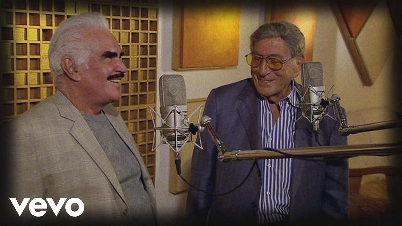 Tony Bennett’s “Return to Me (Regresa a Mí)” is a captivating track from his 2012 album Viva Duets. Known for its heartfelt emotion and rich musicality, this song exemplifies Bennett’s talent for blending classic standards with contemporary flair. Featuring a lush arrangement and a powerful duet with Latin music star Marc Anthony, this rendition of the timeless ballad has become a favorite among fans and critics alike. In this blog post, we’ll dive into the essence of “Return to Me (Regresa a Mí),” explore its lyrical and musical elements, and discuss why this track continues to resonate with listeners. The Essence of “Return to Me (Regresa a Mí)” “Return to Me (Regresa a Mí)” is a beautifully crafted song that showcases Tony Bennett’s enduring appeal and his ability to connect with audiences across genres. Originally a hit in the 1950s, the song has been reimagined by Bennett in his 2012 album Viva Duets. The album features a series of duets with a diverse array of artists, highlighting Bennett’s versatility and his skill at blending different musical styles. Lyrical Themes and Emotional Impact The song’s lyrics are a poignant plea for a loved one’s return, expressing longing and heartfelt desire. With lines like “Return to me, oh my dear, I’m so lonely,” the song captures the essence of yearning and emotional vulnerability. The bilingual nature of the track adds an extra layer of depth, with the English and Spanish lyrics blending seamlessly to convey the song’s universal themes of love and separation. The emotional impact of “Return to Me (Regresa a Mí)” is amplified by Tony Bennett’s soulful performance and Marc Anthony’s passionate contribution. Bennett’s rich, warm voice conveys a deep sense of longing and sincerity, while Anthony’s vocals add a dynamic and emotive quality to the duet. The combination of their voices creates a powerful and moving rendition that resonates deeply with listeners. Musical Composition and Style Musically, “Return to Me (Regresa a Mí)” features a lush orchestral arrangement that enhances the song’s romantic and nostalgic feel. The track’s instrumentation includes sweeping strings, gentle percussion, and a smooth piano accompaniment, creating a rich and immersive listening experience. The arrangement is characterized by its elegance and sophistication, with a blend of Latin and traditional jazz influences that showcase Bennett’s versatility. The duet format allows for a dynamic interplay between Bennett and Anthony, with each artist bringing their own unique style to the performance. This collaboration adds a fresh and vibrant dimension to the classic ballad, making it both a tribute to its origins and a modern reinterpretation. The Impact and Legacy of the Song “Return to Me (Regresa a Mí)” has had a significant impact since its release on Viva Duets. The album itself was well-received, highlighting Tony Bennett’s ability to bridge different musical genres and connect with a broad audience. The song’s success is a testament to Bennett’s enduring talent and his ability to breathe new life into classic standards. The track’s bilingual nature and its fusion of Latin and jazz elements reflect the growing trend of cross-cultural collaborations in music. By featuring Marc Anthony, a renowned Latin artist, Bennett not only expands his musical horizons but also introduces the classic song to new audiences. This cross-genre approach has helped solidify the song’s place as a contemporary classic while honoring its musical heritage. Why “Return to Me (Regresa a Mí)” Endures The enduring appeal of “Return to Me (Regresa a Mí)” can be attributed to several factors. First, the song’s emotional depth and universal themes of love and longing resonate with listeners of all backgrounds. Its ability to convey profound emotions through a combination of English and Spanish lyrics adds a unique and relatable dimension. Second, Tony Bennett’s masterful performance and Marc Anthony’s passionate contribution bring a fresh and vibrant quality to the track. Their collaboration showcases their respective talents while creating a dynamic and memorable rendition of the classic ballad. Finally, the song’s sophisticated musical arrangement and its blend of Latin and jazz influences ensure its continued relevance and popularity. The track stands as a testament to Bennett’s ability to adapt and innovate while remaining true to the essence of the original song. Conclusion Tony Bennett’s “Return to Me (Regresa a Mí)” from Viva Duets is a remarkable example of how classic standards can be reinterpreted and revitalized through collaboration and musical innovation. With its heartfelt lyrics, elegant arrangement, and dynamic duet with Marc Anthony, the song captures the essence of longing and love in a way that resonates deeply with audiences. As we celebrate the legacy of Tony Bennett, “Return to Me (Regresa a Mí)” stands out as a testament to his enduring artistry and his ability to connect with listeners across generations.